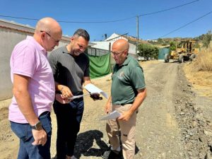Obras de acondicionamiento de un camino rural en Cártama, con maquinaria extendiendo zahorra sobre el firme
