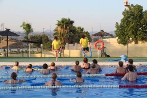 Autoridades municipales y bañistas en el arranque de la Campaña Municipal de Natación en una piscina de Cártama.