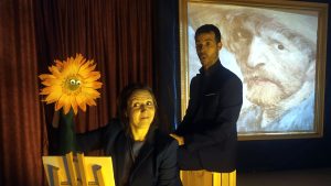 Escena del espectáculo 'Museum: La Historia del Arte para Niños y Niñas', de La Líquida Teatro, con actores, títeres y proyecciones en directo